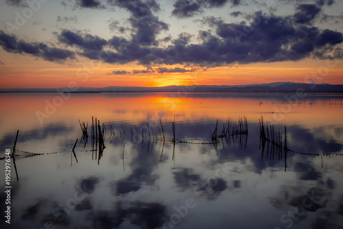Sunset at the Albufera lagoon in Valencia, Spain, with orange and dark blue tones.