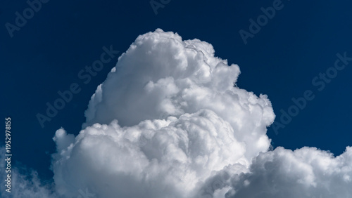 Towering white cumulus clouds against blue sky
