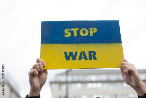 Demonstrator holding sign stop war placard. Ukraine war crisis. Anti war protests in Germany