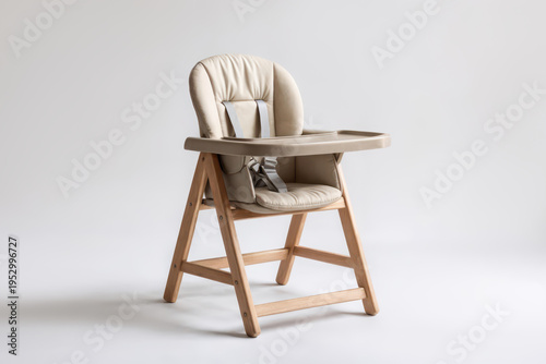 A high chair made of wood and soft material stands alone on a plain background. This chair is designed for children to sit comfortably during mealtime.
