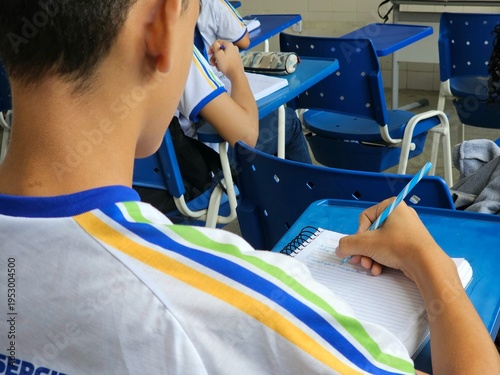 Tableau sur toile Aluno escrevendo no caderno durante aula em sala