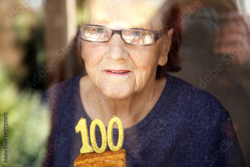 Foto Portrait of an elderly woman with glasses holding anniversary candles