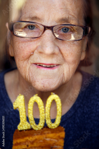 Canvastavla Portrait of an elderly woman with glasses holding anniversary candles