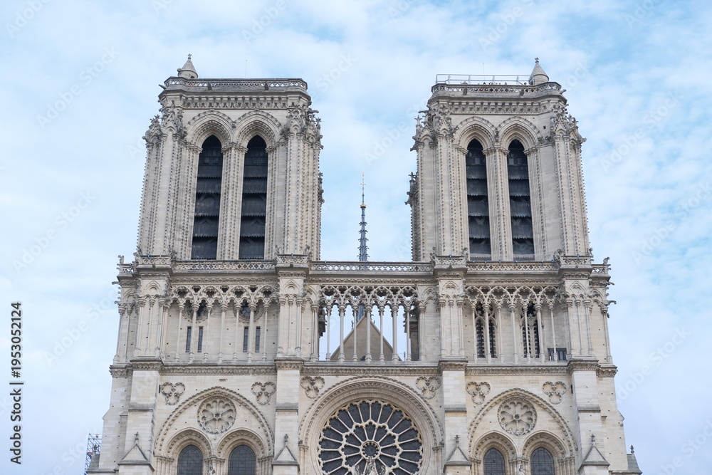 Fototapeta premium Front facade of Notre Dame de Paris on blue sky background. Traveling to Europe, sightseeing, visiting important religious places. Notre-Dame Cathedral in France