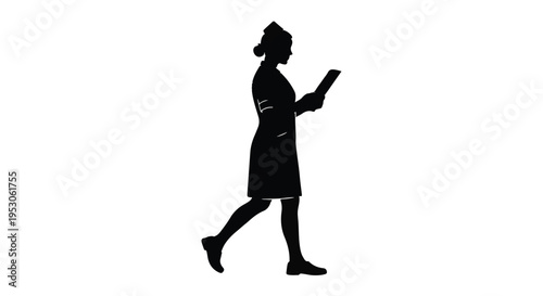 Silhouette of young professional businesswoman walking with tablet in hand outdoors during daytime