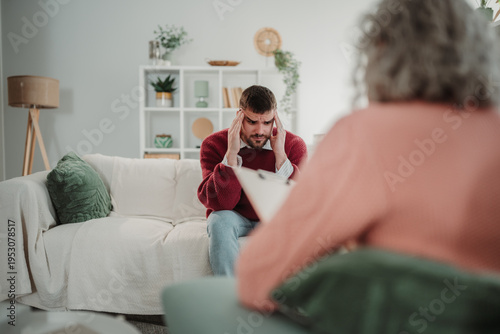 Fotografie Stressed man having therapy session with a psychologist
