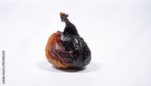 Dark decaying fig with shriveled sticky texture isolated on white