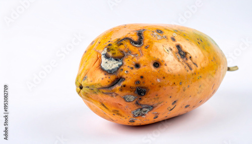 Soft and decaying papaya with bruised skin and spots isolated on white