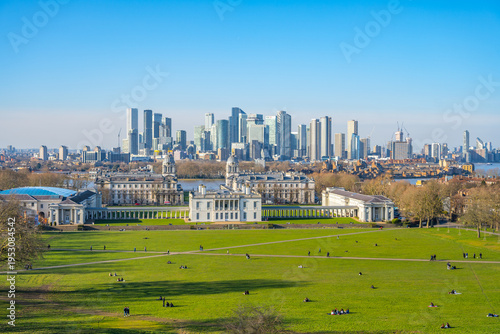 Obraz na plátně Visitors enjoy a sunny day at Greenwich Park, surrounded by lush green grass and historic buildings
