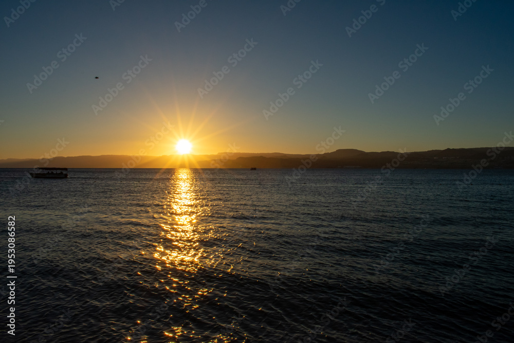 Fototapeta premium Beautiful sunset over Red Sea, view over Aqaba Gulf from Jordan, Israel and mountains on a Background. 