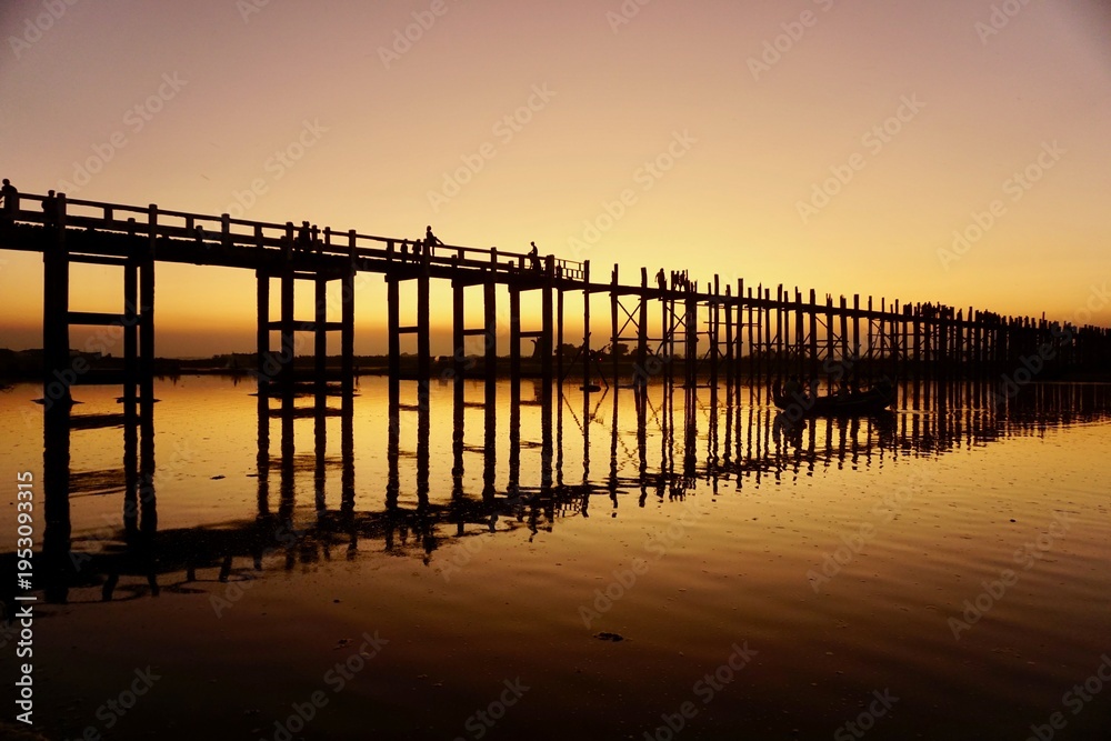 Obraz premium U-Bein Bridge at sunset with orange sky, iconic teak bridge in Myanmar