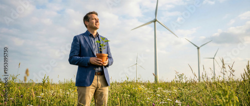 Wallpaper Mural Businessman holding a small plant in a pot standing in a field with wind turbines in the background Torontodigital.ca