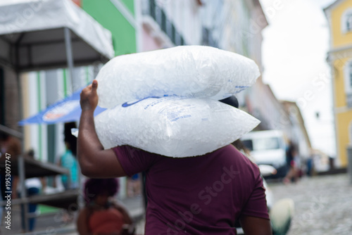 Worker carrying bags of ice