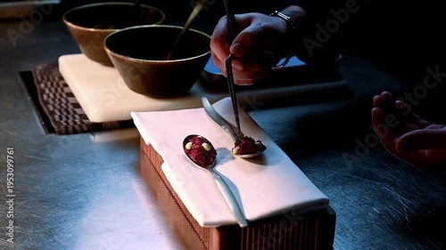 Chef meticulously plates tasty tartare. Refined plating with sauces and ambient lighting