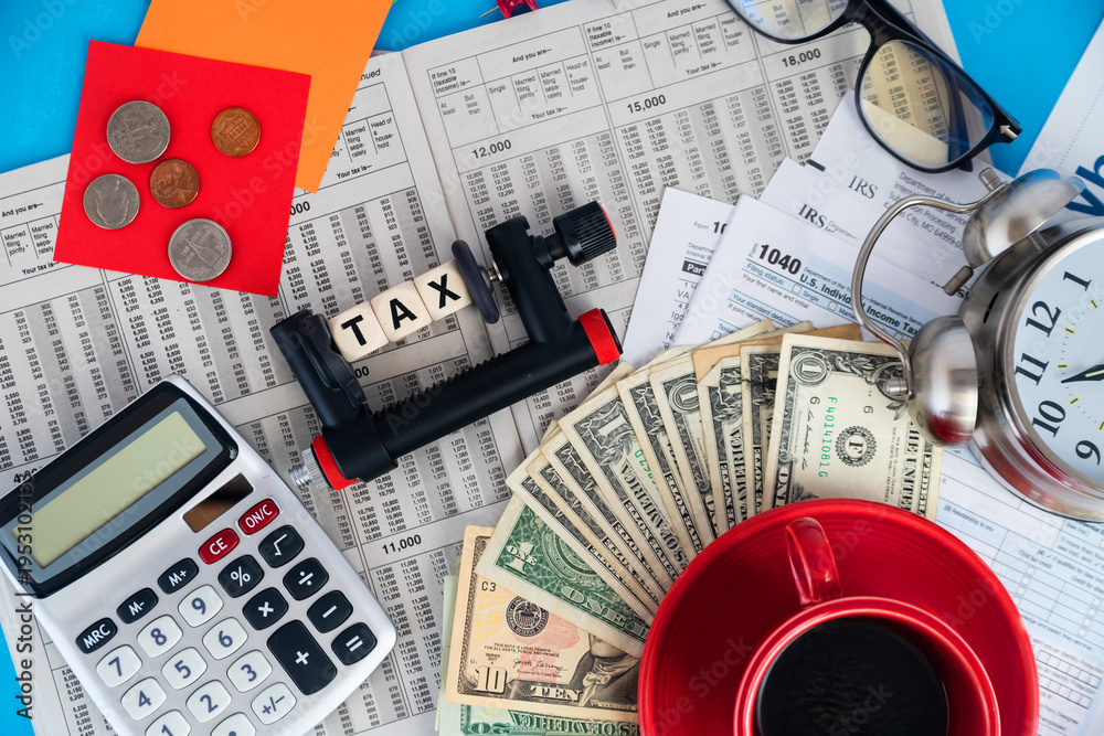 Fototapeta premium US tax concept with dollar bills calculator and 1040 form paperwork on desk