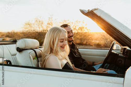 happy couple smiling in convertible car