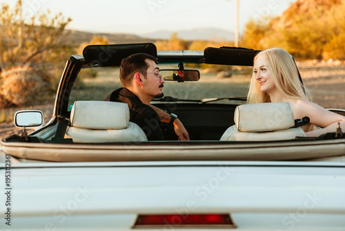 young couple in car parked in the desert