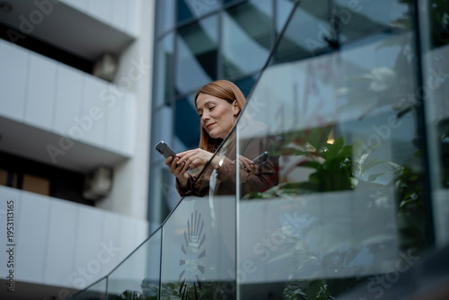 Bild auf Leinwand Professional woman communicating using smartphone in modern building