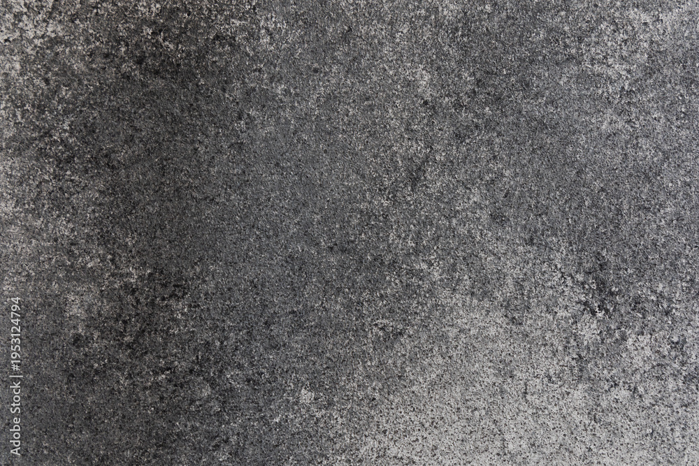 Fototapeta premium Close-up view of a textured surface with shades of gray showing rough and smooth patterns in natural light