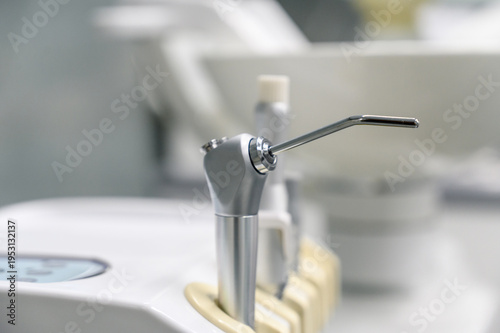 Dental equipment close-up with dental handpiece and sink in background