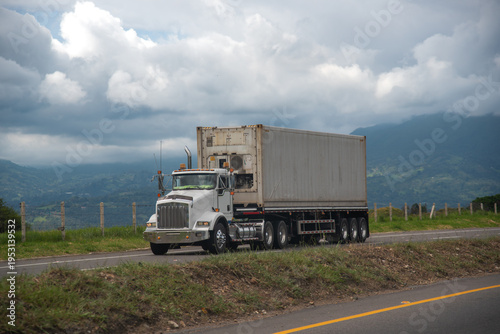 Truck with refrigerated container on a Colombian highway between the Andes Mountains.