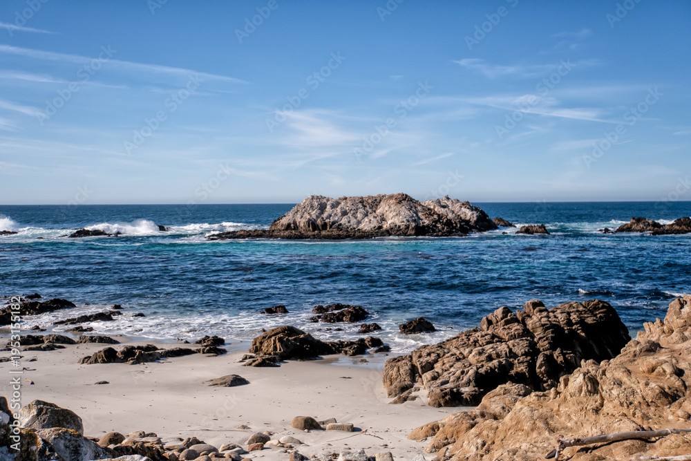 Fototapeta premium Sandy beach meets rocky outcrops and deep ocean waves