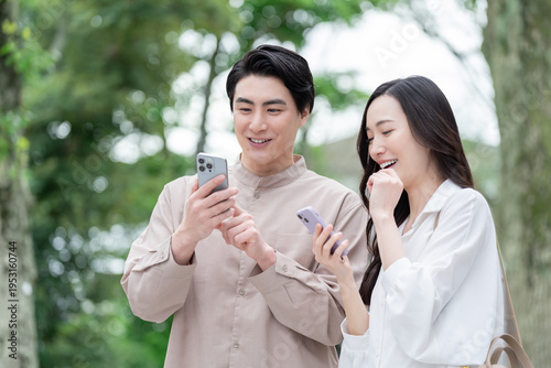 屋外でスマホを見る男女カップル