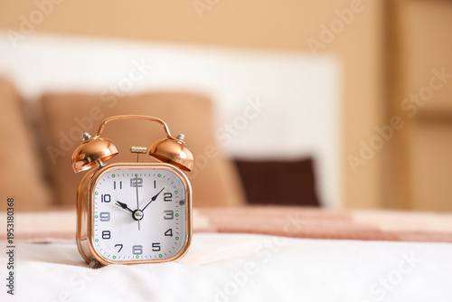 Golden alarm clock on bed, ...