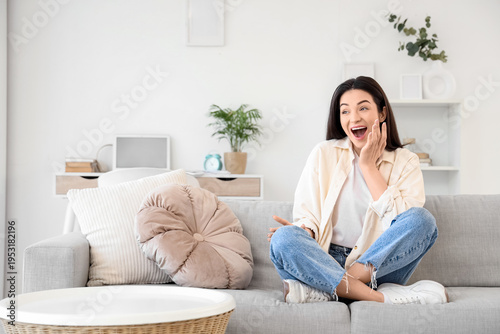 Surprised young woman sitti...