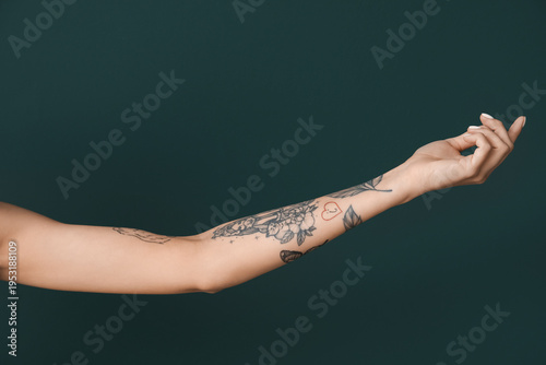 Tattooed female hand on gre...