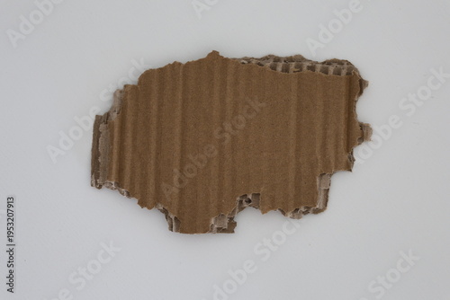 Ripped brown corrugated cardboard with rough edges isolated on white background. Packaging and recycling concept with copy space.