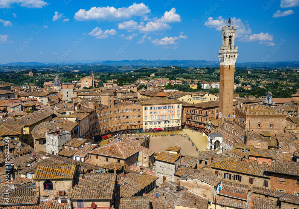 Obraz premium A panoramic view over Piazza del Campo, the heart of Siena, surrounded by medieval buildings and dominated by the Torre del Mangia. 