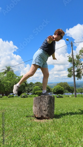 Woman balancing on the tree trunk