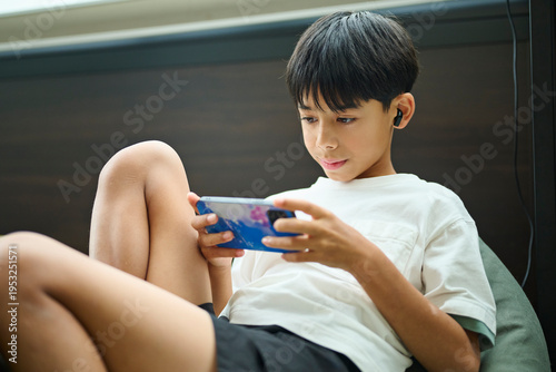 スマホゲームに集中する男の子のクローズアップ