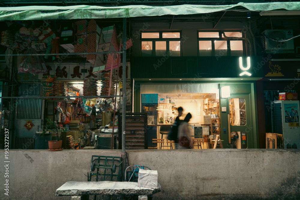 Naklejka premium HONG KONG - MARCH 19, 2026: A local traditional paper offering shop and a modern store side by side in a Hong Kong neighborhood.