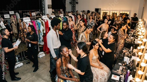 A diverse group of people in a makeup and hair styling station, with a focus on women in black dresses and men in suits, with a mix of black.