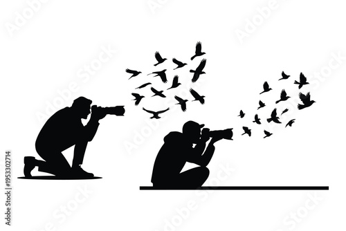 Silhouettes of two photographers taking of flying birds