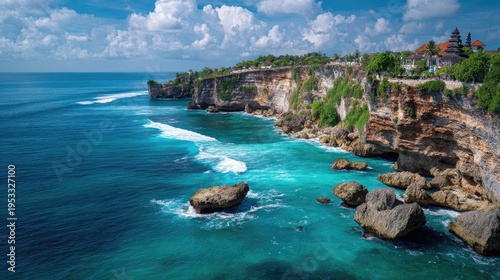 Breathtaking coastal view of turquoise waters crashing against rocky shorelines under a vibrant blue sky and dramatic clouds, showcasing nature's beauty