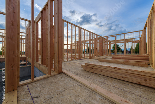 Fotografie A new home in the framing phrase of residential construction with walls built and a concrete foundation for structural support