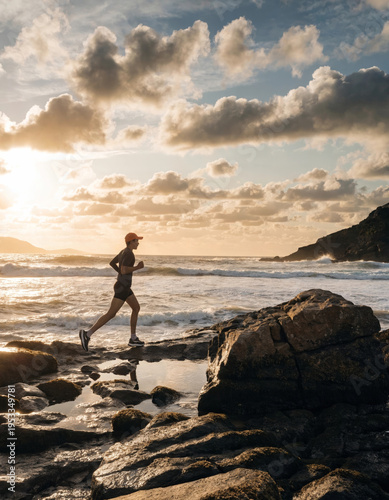 Runner jogging ocean sunrise rock coastline fitness outdoor silhouette sky Runner jogging along rocky ocean coastline sunrise, athletic silhouette moving near crashing wave and dramatic cloud sky