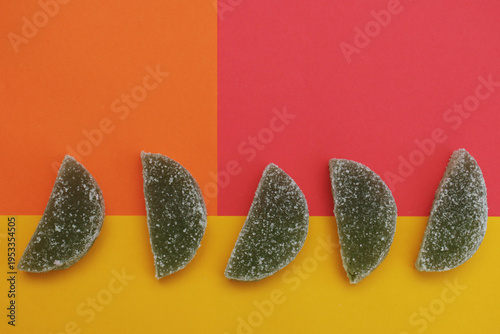 Five gummy citrus slices arranged in a row