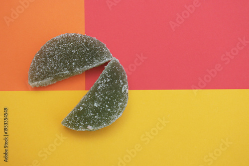 Two dark, sugary halves rest against bold, split-color background