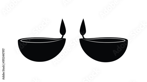 Two traditional clay lamps with burning wicks striking black silhouette