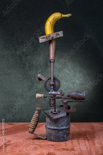 Obraz na plátně A piece of a ripe banana, a hand drill, and a blowtorch