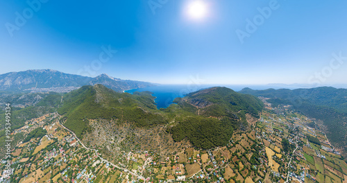 Wallpaper Mural Kayakoy, Turkey. Drone panoramic photo of abandoned stone ruins integrated into natural mountain landscape with forested slopes and Mediterranean vegetation under clear blue sky. Aerial view Torontodigital.ca