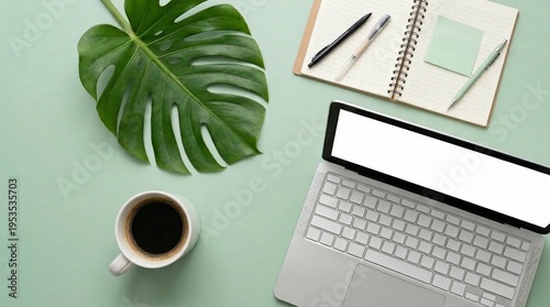 Serene Workspace with Tropical Leaf Coffee and Laptop Displaying Blank Screen