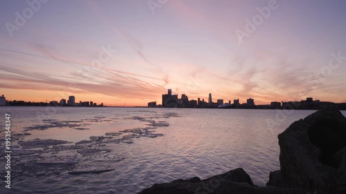 Tucked behind rocks, the Detroit Skyline stands out over the icy waters of the Detroit River from the vantage point at Belle Isle Park.
