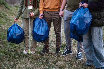 Volunteers collecting garbage with trash bags and grabbers