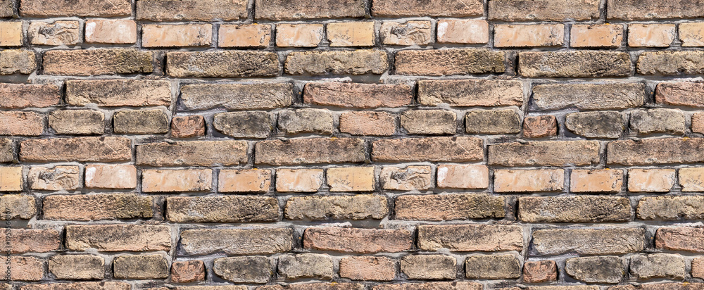 Fototapeta premium Rustic, aged brick wall texture. A seamless background featuring weathered brown and red bricks with dark mortar