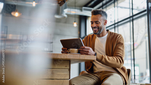 Independent digital creator smiling with deep satisfaction while reading overwhelmingly positive audience feedback on his tablet.